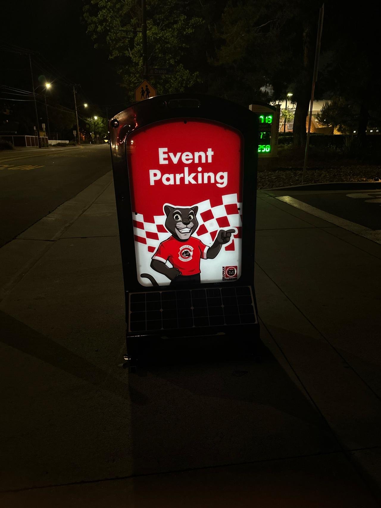 Illuminated sign glowing at night for campus event parking