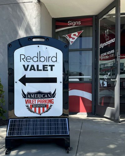 Illuminated sign used for valet parking signage outside a storefront